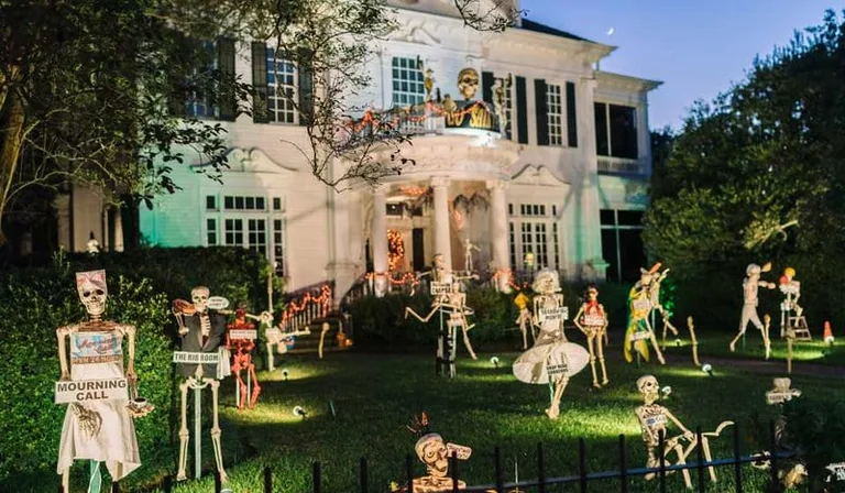 A New Orleans mansion, its lawn decorated with skeletons.