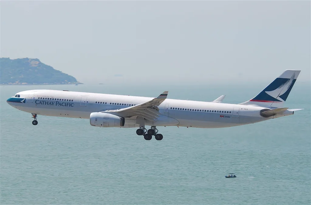 Plane of Cathay Pacific Flying Over the Ocean