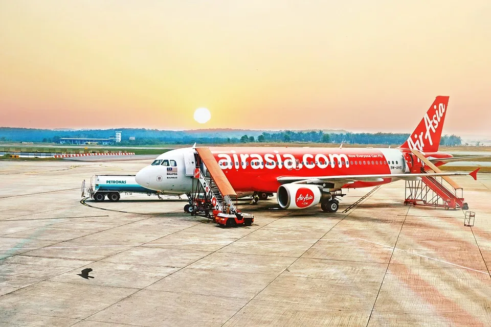 Red AirAsia Plane on a Runway at Sunset