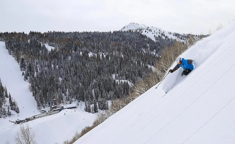 A skier sliding down on a slope in park City