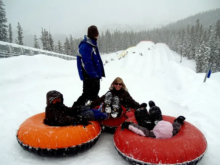A couple of snow tubers gonig down a mountain